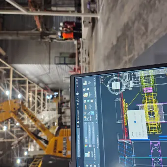 Plano técnico digital frente a una planta industrial