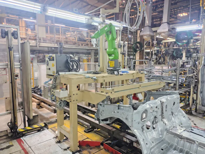 Robot industrial frente a una pieza de carrocería